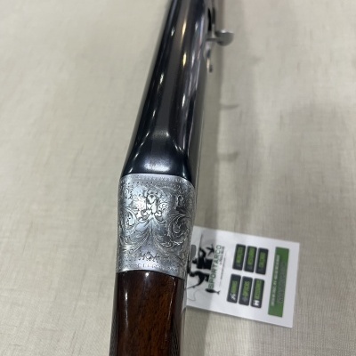 Espingarda de cano duplo com detalhes prateados e coronha em madeira