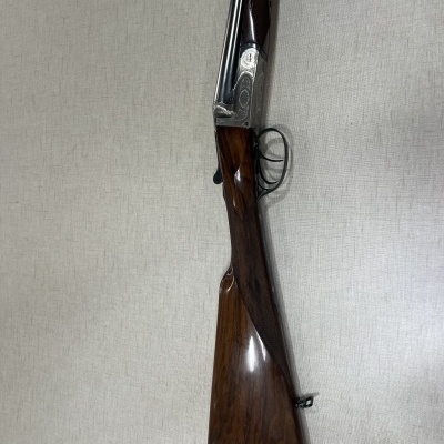 Espingarda de cano duplo com detalhes gravados e madeira castanha polida