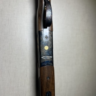 Espingarda de madeira e metal com detalhes dourados e padrão floral