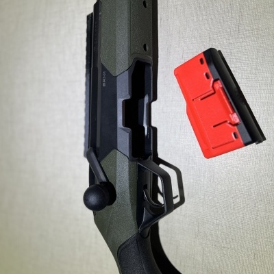 Espingarda com carregador vermelho destacado ao lado