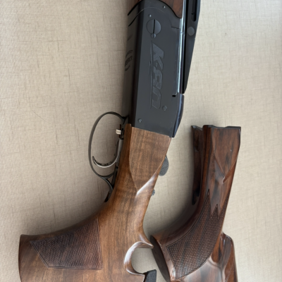 Espingarda com coronha de madeira castanha e corpo metálico negro