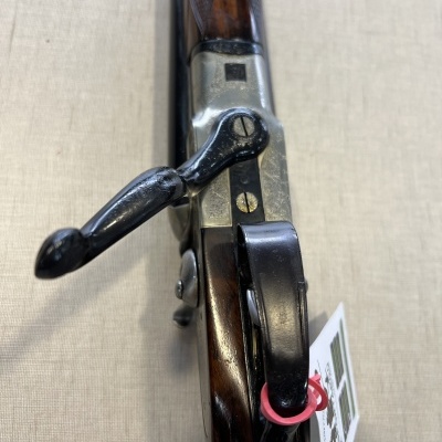 Carabina de madeira e metal com etiqueta pendurada e padrão texturizado na madeira