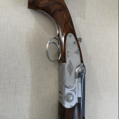 Espingarda com madeira escura entalhada e armação metálica prateada decorada