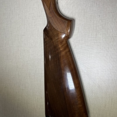 Coronha de madeira castanho escuro de arma de fogo contra fundo branco texturizado