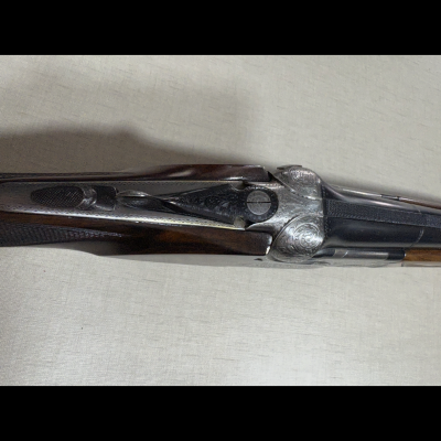 Espingarda de canos duplos com detalhe em madeira e metal gravado