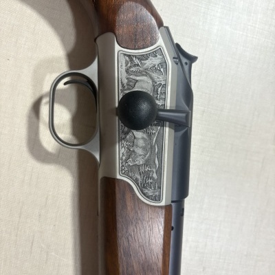 Corpo de arma de fogo com punho de madeira e gravação metálica detalhada de cervo