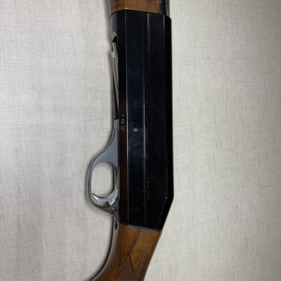 Espingarda com cabo de madeira castanha e corpo metálico preto