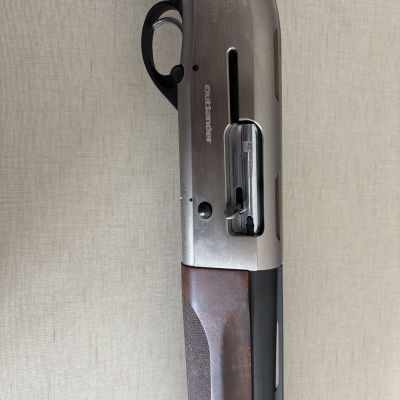 Escopeta Beretta Outlander com punho de madeira castanha e corpo metálico prateado e preto