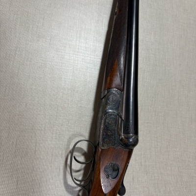 Espingarda de canos duplos com coronha em madeira e caixa em metal gravada