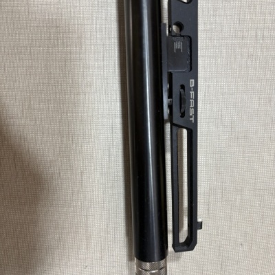 Cano de arma negro com extremidade verde e letras VERITTA e estrutura preta com texto B-FAST