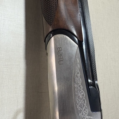 Arma de fogo com cano metálico e punho em madeira castanha