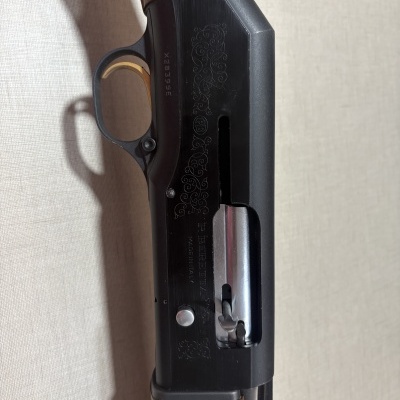 Espingarda de caça com cabo em madeira e corpo metálico preto