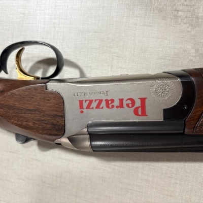 Espingarda Perazzi com madeira escura e detalhes metálicos