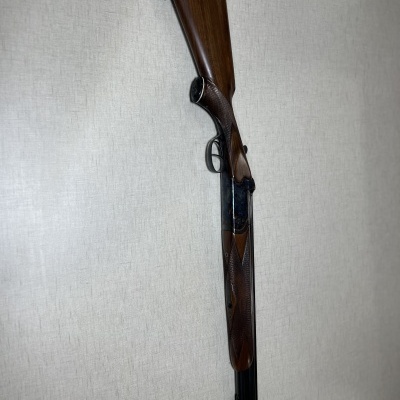 Espingarda com coronha e canos duplos pendurada na parede