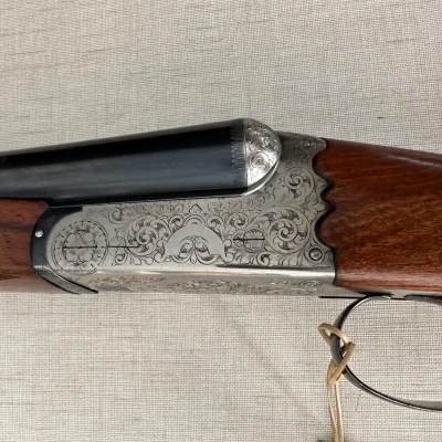 Espingarda de canos duplos com gravações e empunhadura em madeira