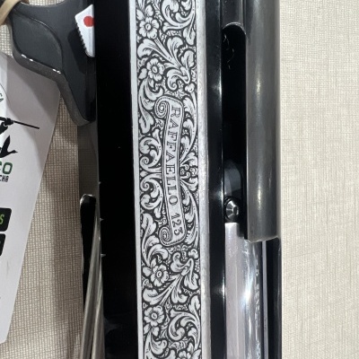 Arma com gravação floral prateada e texto RAFFAELLO 125 na lateral