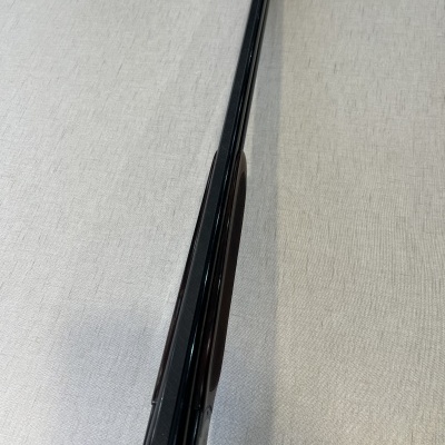 Arma de cano duplo com coronha de madeira escura e canos metálicos pretos