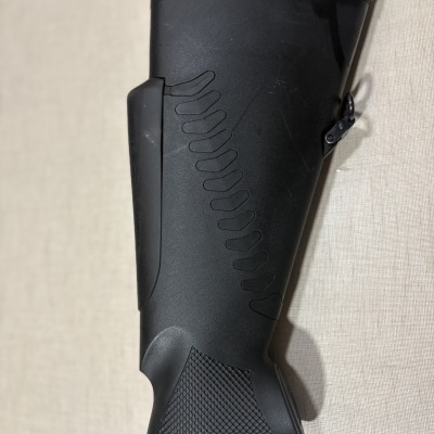 Espigão de arma preto com textura antiderrapante numa superfície clara