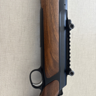 Rifle Sauer 303 de madeira e metal com inscrições e acabamento azul escuro.