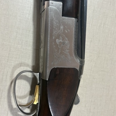 Espingarda de canos duplos com madeira escura e metal prateado decorado