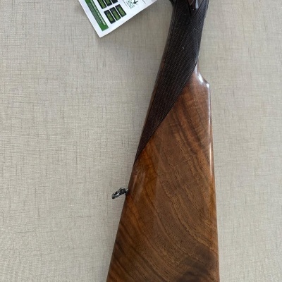 Espingarda com coronha de madeira polida e detalhes em metal escuro