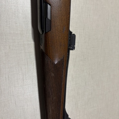 Coronha de madeira castanha e partes metálicas pretas de um rifle