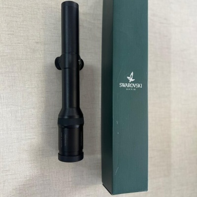 Luneta preta com caixa verde da Swarovski Optik sobre superfície clara