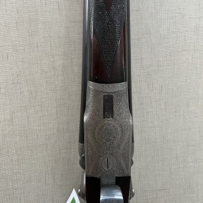 Parte superior de espingarda em madeira e metal cinzento com gravuras