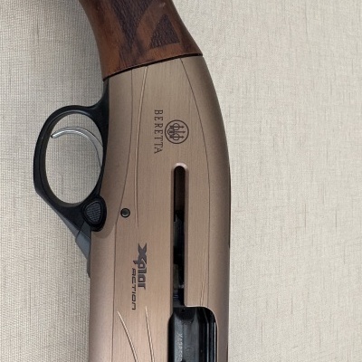 Espingarda Beretta com madeira castanha e corpo bege com texto preto XPLOR ACTION