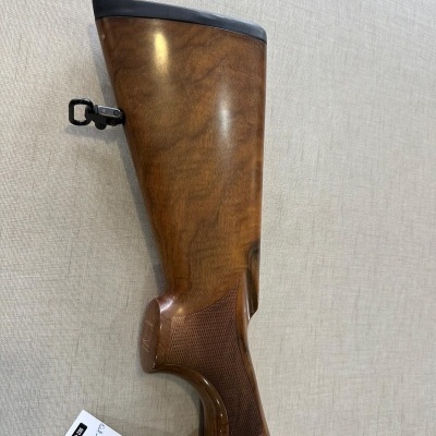 Coronha de espingarda em madeira castanha polida com acabamento preto e etiqueta branca