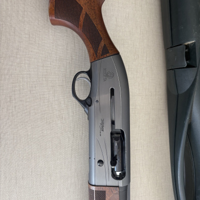 Espingarda Beretta com coronha de madeira castanha e ação metálica cinza