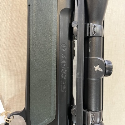 Carabina Steyr 30.6 com mira telescópica preta sobre superfície clara