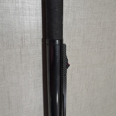 Bastão preto com empunhadura texturada e clip com padrão de fibra de carbono