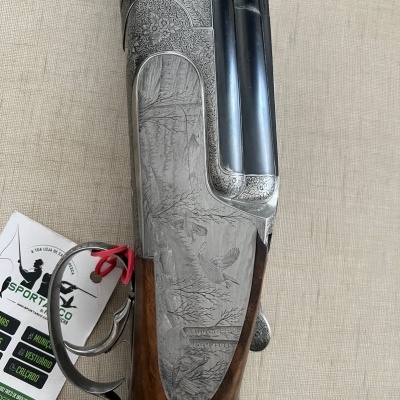 Espingarda com gravação detalhada em metal e madeira escura sobre fundo de tecido bege