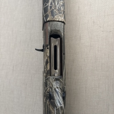 Espingarda camuflada de cano curto com detalhe da câmara aberta