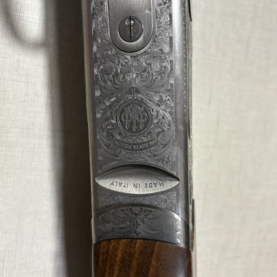 Parte de arma com gravação e madeira escura