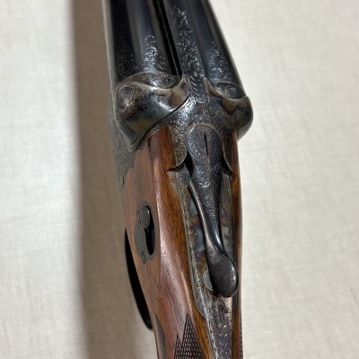 Espingarda de canos duplos com coronha de madeira e detalhes gravados em metal