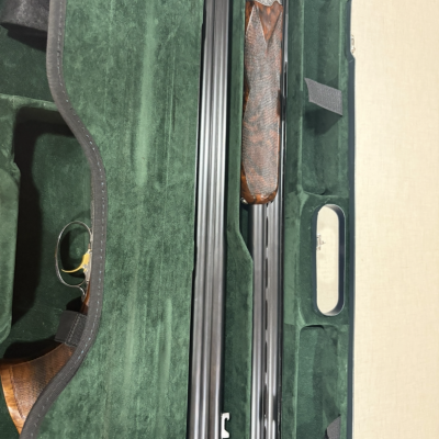 Espingarda desmontada em estojo verde almofadado com coronha em madeira e cano metal negro