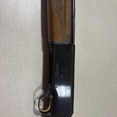 Espingarda de caça com madeira castanha e metal preto gravado