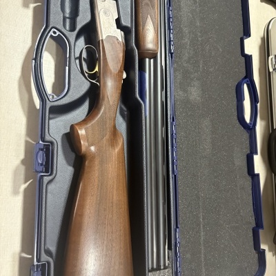 Espingarda desmontada em estojo azul acolchoado.