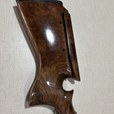 Coronha de arma em madeira polida com entalhes e gatilho dourado