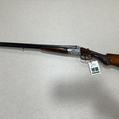 Espingarda de canos paralelos em madeira e metal com etiqueta pendurada