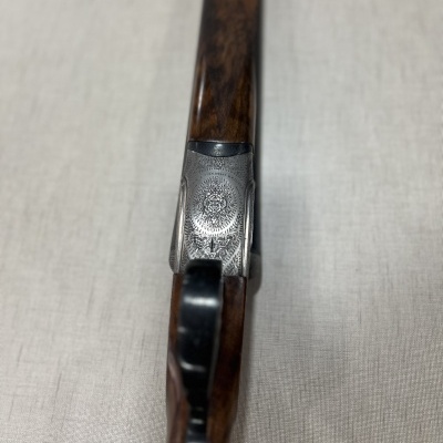 Espingarda de cano duplo com cabo de madeira castanha e detalhes em metal gravado