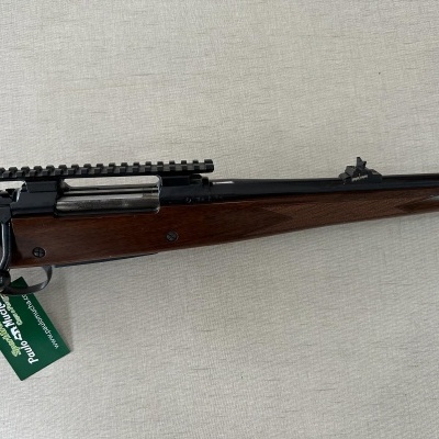 Espingarda com coronha em madeira castanha e caixa preta com tag verde