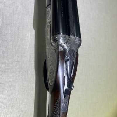 Espingarda de canos duplos com detalhes gravados e coronha de madeira escura
