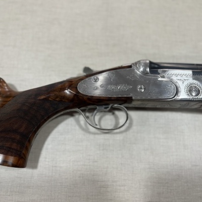 Espingarda de caça com coronha em madeira e detalhes metálicos gravados