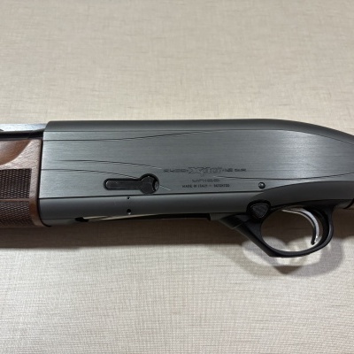 Espingarda de caça com madeira e metal cinza com texto preto