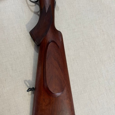 Arma de fogo com madeira castanha polida e detalhes entalhados