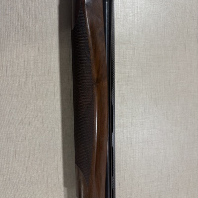 Espingarda com madeira castanha e detalhes em metal prateado