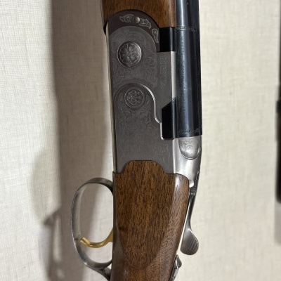 Espingarda de caça com madeira castanha e corpo metálico cinzento gravado